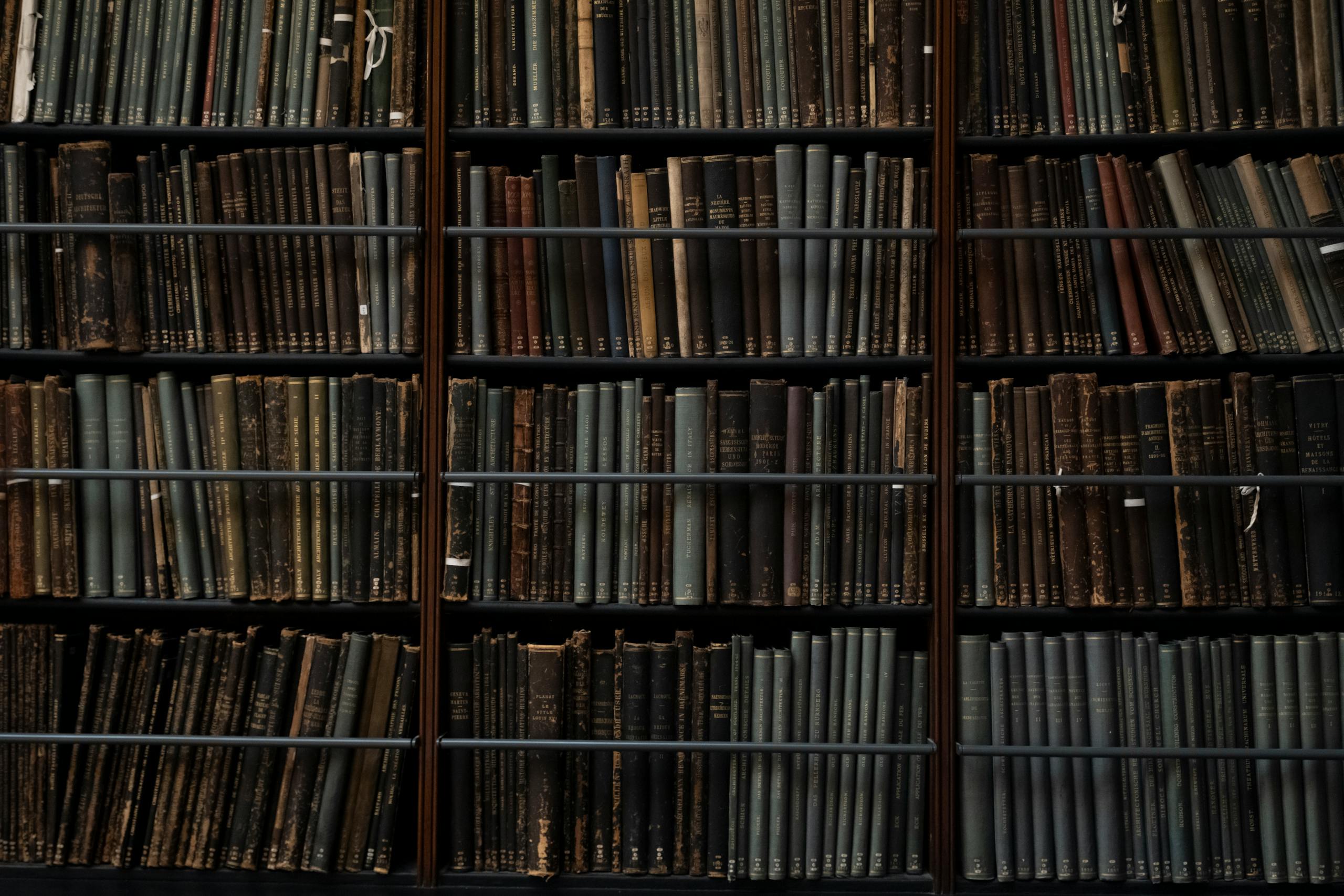 A close-up of vintage books on library shelves in London, showcasing an abundance of literary history.